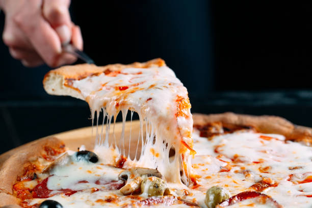 a slice of pizza being cut with cheese hanging to it